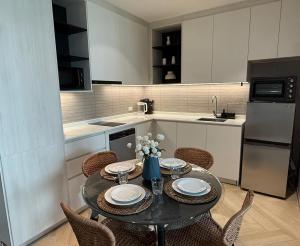 a kitchen with a dining table with chairs and a kitchen with white cabinets at The Legendary Bang Tao 2-bedrooms apart #402 in Bang Tao Beach +30 photos