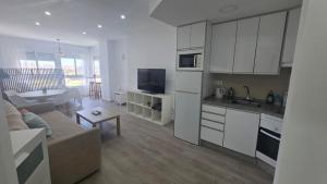 a kitchen and living room with a couch and a table at Estudio Bellavista La Colina in Torremolinos