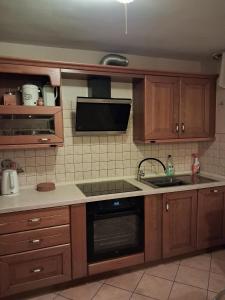 a kitchen with wooden cabinets and a sink and a microwave at Dom Borowski in Bukowiec +19 photos