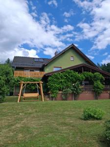 a house with a swing in the yard at Dom Borowski in Bukowiec