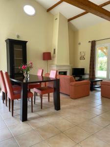 a living room with a dining room table and chairs at French country home II in Les Forges