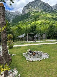 a fire pit in a yard with mountains in the background at The Overlook in Bogë
