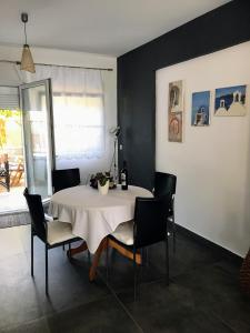 a dining room with a white table and chairs at Apartment Michail in Skála Nikíta