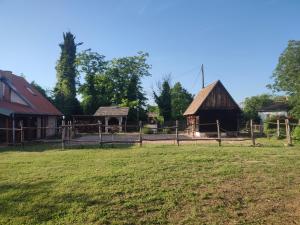 a farm with a fence and a barn at Glas house Aljmaš in Aljmaš