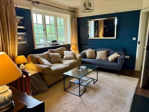 a living room with a couch and a table at Recently renovated Lodge Cottage, Quantocks in West Bagborough