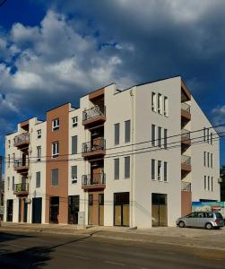 a white building with a car parked in front of it at D&M Lux1 in Podgorica
