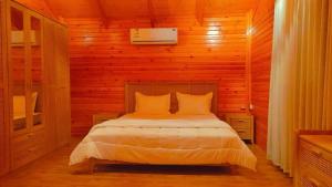 a bedroom with a bed in a wooden cabin at أكواخ واستراحه ريف عسير in Abha