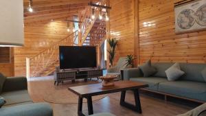 a living room with couches and a flat screen tv at أكواخ واستراحه ريف عسير in Abha