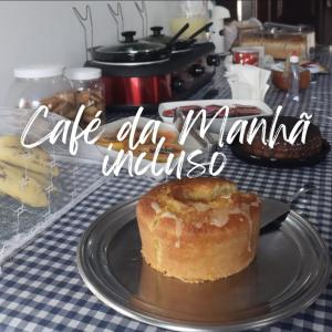 a table with a plate with a pastry on it at Pousada Casa da arara Suite 106 in Saquarema