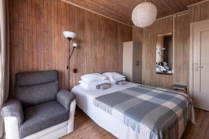 ein Schlafzimmer mit einem Bett und einem Stuhl in der Unterkunft Zunda in Nida