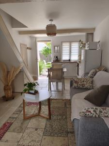 a living room with a couch and a table at Maison Auguste - cosy - terrasse in Verberie