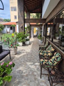 a patio with couches and plants in a yard at Pousada Casa da arara Suite 106 in Saquarema