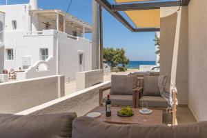 a patio with a table and chairs and the ocean at Ostria Vento in Pollonia