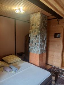 a bedroom with a bed and a stone wall at Верх Довбуша in Vorokhta