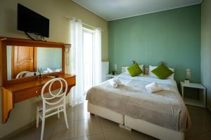 a bedroom with a bed and a desk and a television at Villa Muses in Poros