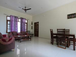 a living room with a couch and chairs and windows at Panchsheel Villa Bhimtal in Bhīm Tāl