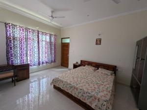 a bedroom with a bed and two large windows at Panchsheel Villa Bhimtal in Bhīm Tāl