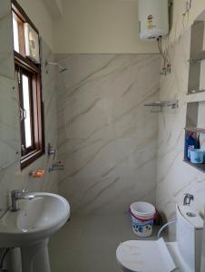 a white bathroom with a sink and a toilet at Panchsheel Villa Bhimtal in Bhīm Tāl