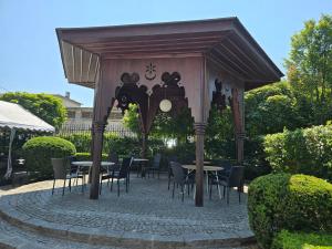 a gazebo with tables and chairs in a garden at Hotel i Restauracja Pałacyk Tyrolski in Żyrardów