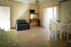 a living room with a table and a chair at Villa Muses in Poros