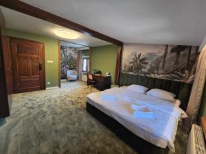 a bedroom with a large bed with a painting on the wall at Hotel i Restauracja Pałacyk Tyrolski in Żyrardów