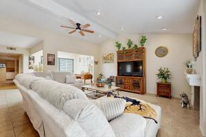 a living room with two white couches and a tv at Palm Paradise in Palm Desert
