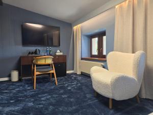 a room with a desk and a chair and a table at Hotel i Restauracja Pałacyk Tyrolski in Żyrardów