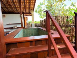 a hot tub on the deck of a house at Chalé Átina - Atins in Atins