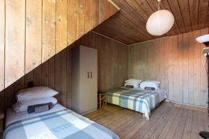 zwei Betten in einem Zimmer mit Holzwänden in der Unterkunft Zunda in Nida