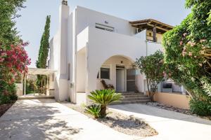 a white house with trees and flowers at PhώS Casa Lachania in Lachania