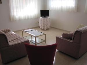 - un salon avec deux chaises et une télévision dans l'établissement Luz de Azahar Bed and Breakfast, à Peñíscola