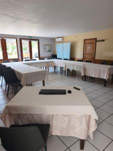 a room filled with tables with white tablecloths at Maison Legate "Hôtel Le Baudiere & Spa" in Saint-Beauzire