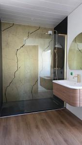 a bathroom with a sink and a mirror at Ecrin d'exception avec jacuzzi et salon cinéma in Penne-dʼAgenais