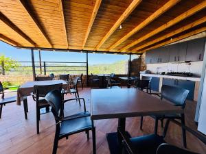 a dining room with tables and chairs and a kitchen at Petros rooms in Himare