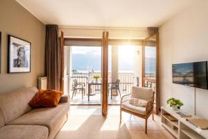 a living room with a couch and a view of a balcony at Lake View Apartments in Acquaseria