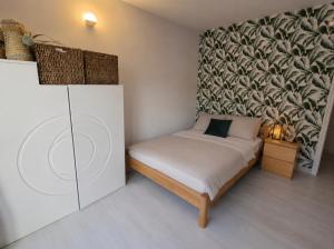 a bedroom with a bed with a large wall at Frida's house in Bièvres