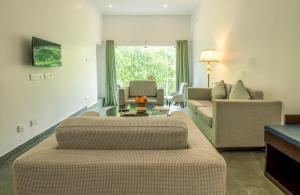 a living room with a couch and a table at Mainland Resorts & Spa by Kolaahalam in Yercaud