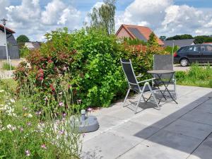 eine Terrasse mit zwei Stühlen, einem Tisch und einem Busch in der Unterkunft FeWoMeißner in Wittingen