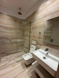 a bathroom with a sink and a toilet and a mirror at The Factory Boutique in Vlorë