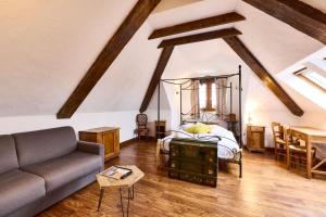 a living room with a bed and a couch at Logis Hotel Domaine de Rouffach in Rouffach +58 photos