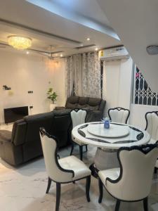 a living room with a couch and a table and chairs at Kingdom home in Amanfro