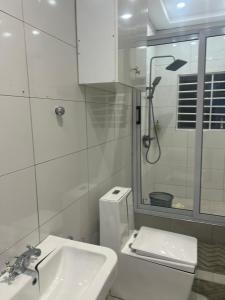 a bathroom with a toilet and a sink and a shower at Kingdom home in Amanfro
