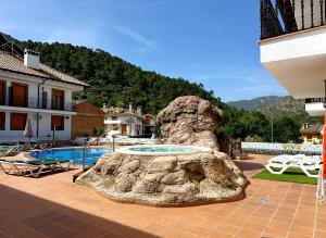 eine Felsenstatue neben einem Schwimmbecken in der Unterkunft Gran Hotel Spa Parque de Cazorla in Arroyo Frio