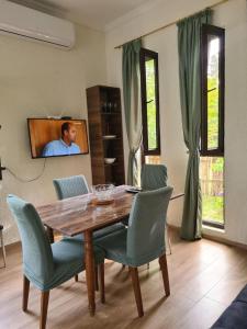 a dining room table with chairs and a tv on the wall at MAG house in Shekhvetili