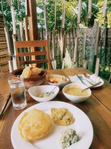 a wooden table with plates of food on it at Borassus Nature Huts by ABC Leisure's group in Jaffna