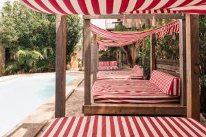 four beds under an umbrella next to a pool at Villa Station by Cassai in Ses Salines