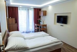 ein Hotelzimmer mit 2 Betten und einem TV in der Unterkunft BL.Apartmanház II. in Szeged