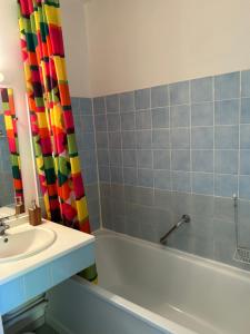 a bathroom with a sink and a shower curtain at Studio ensoleillé avec piscine in Cazaubon +2 photos