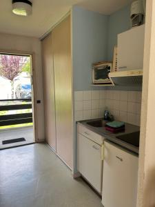 a small kitchen with a sink and a microwave at Studio ensoleillé avec piscine in Cazaubon
