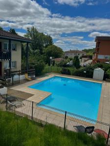 a large blue swimming pool in a yard at Studio ensoleillé avec piscine in Cazaubon